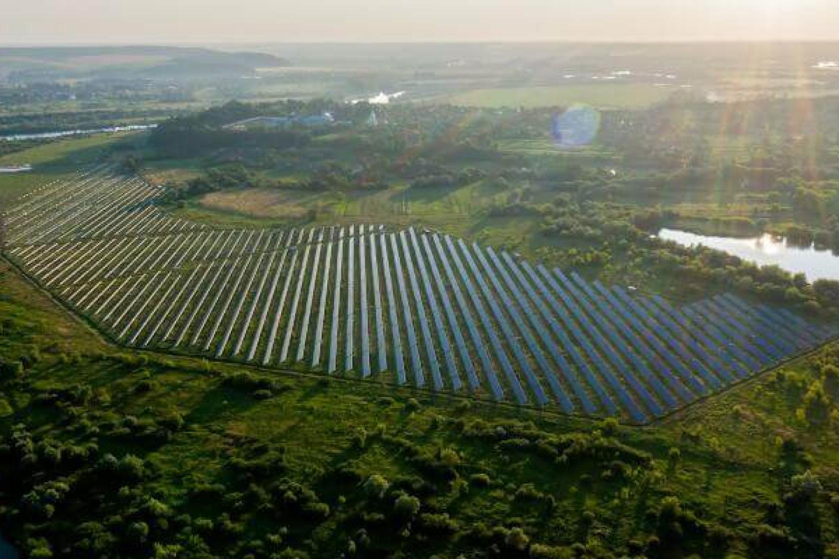 Aerial view of a large solar field in a green rural area
